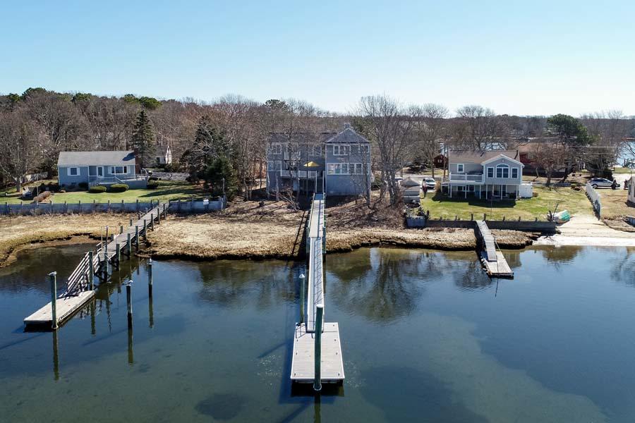 99 Monomoscoy Road West Mashpee, MA 02649 - Photo 2 of 43 a view of a swimming pool with a table and chairs