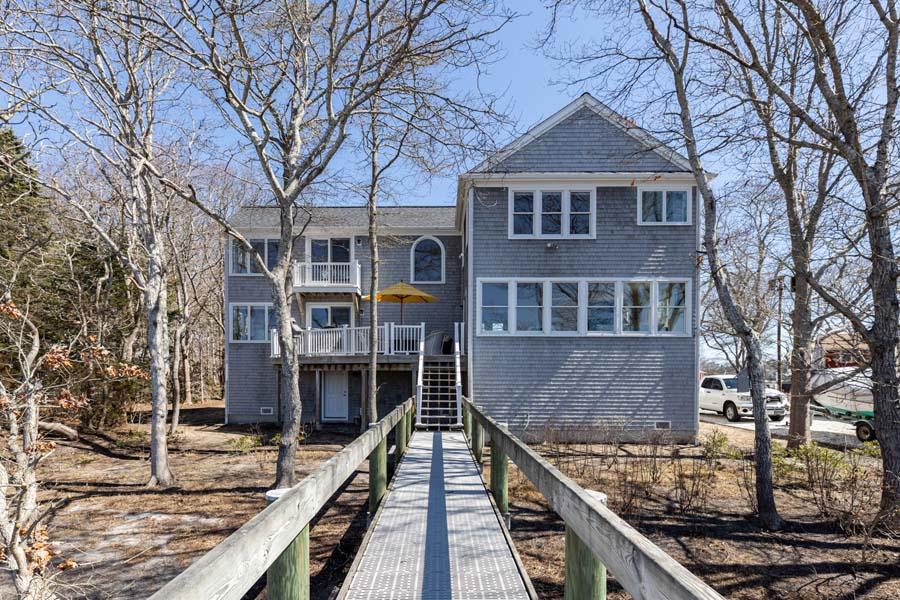 99 Monomoscoy Road West Mashpee, MA 02649 - Photo 33 of 43 a front view of a house with large windows