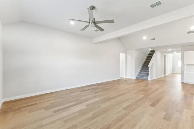 wooden floor in an empty room with a ceiling fan