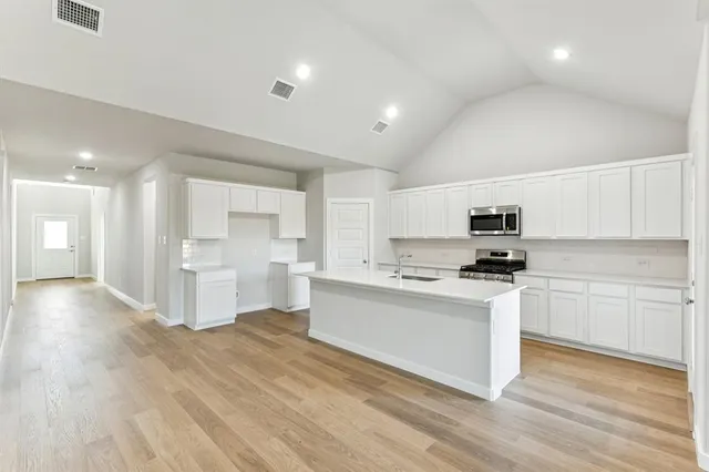 a kitchen with stainless steel appliances a white stove top oven sink and cabinets