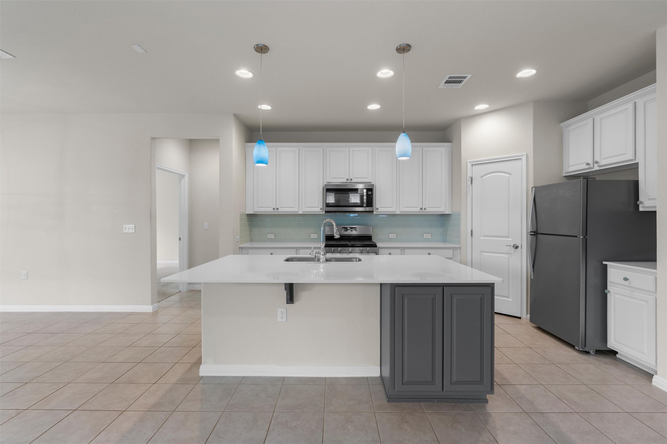 108 Calhoun Lane Georgetown, TX 78633 - Photo 10 of 32 a kitchen with kitchen island a sink stainless steel appliances and cabinets