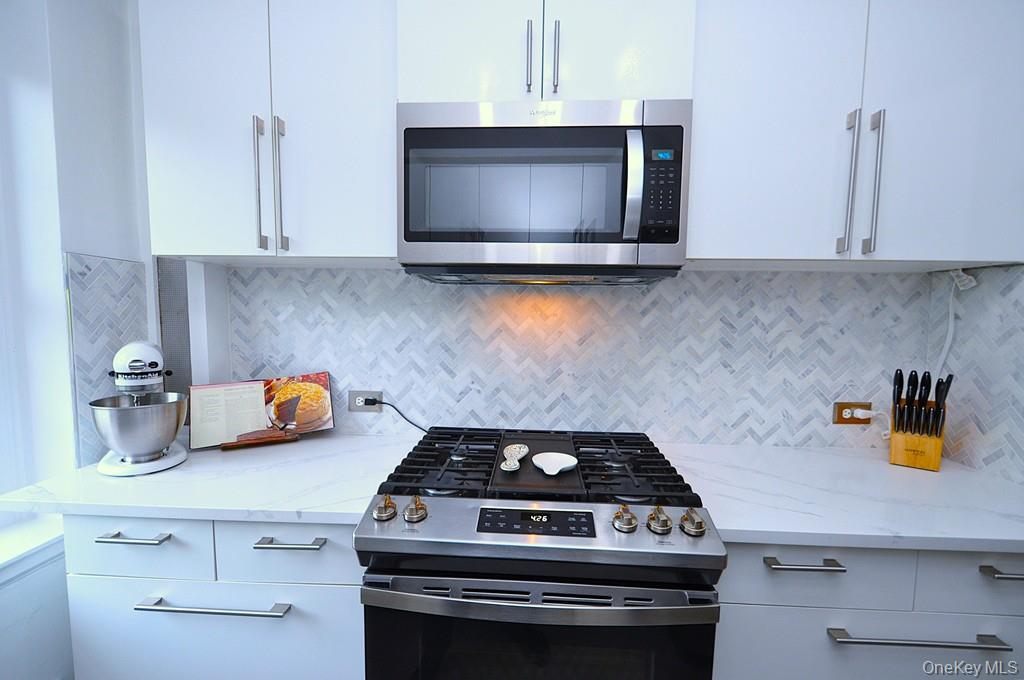 192 Garth Road, Unit TP Scarsdale, NY 10583 - Photo 15 of 43 The thoughtfully renovated kitchen is a chef’s delight, showcasing stainless steel appliances, custom white cabinetry, abundant quartz countertops, and generous workspace.