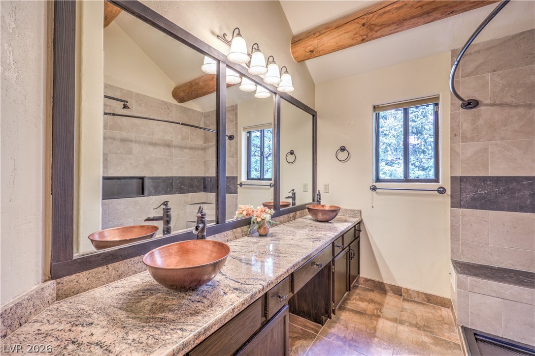 322 Ski Trail Road Mount Charleston, NV 89124 - Photo 23 of 58 Natural stone counters and rustic wooden beams bring warmth to this spacious double vanity bathroom.