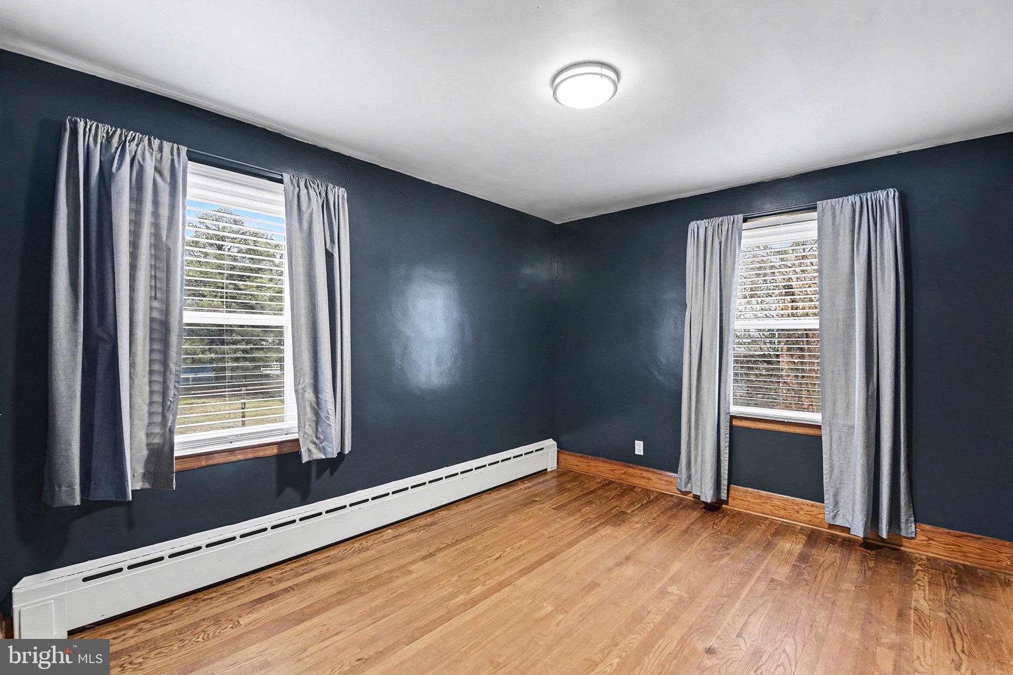 4818 Ridge Road Rosedale, MD 21237 - Photo 18 of 30 an empty room with wooden floor and windows