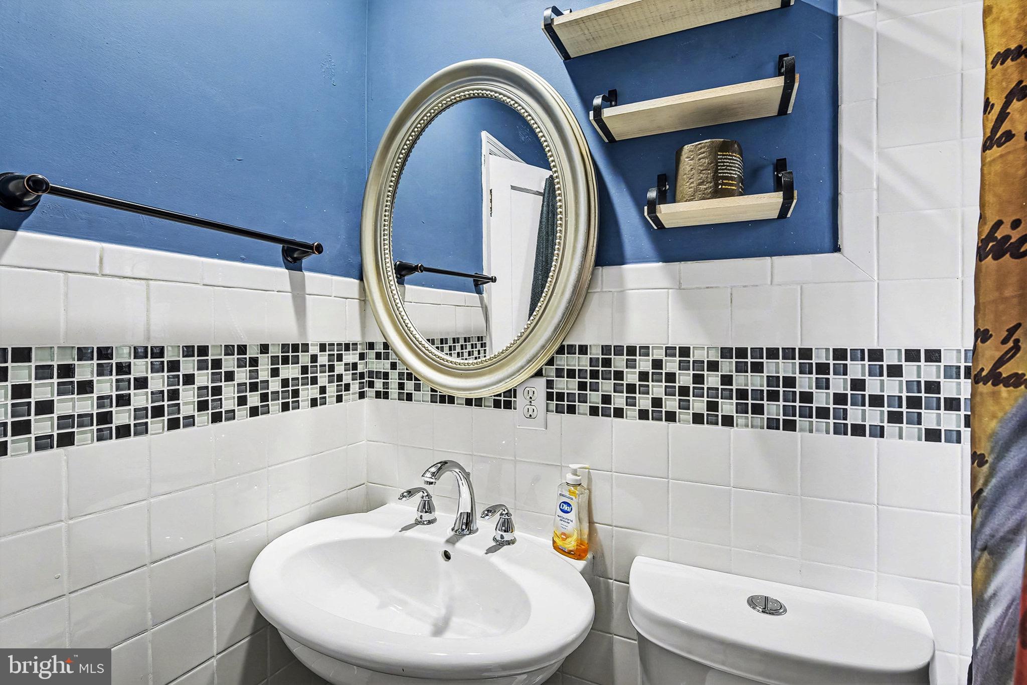 4818 Ridge Road Rosedale, MD 21237 - Photo 20 of 30 a bathroom with a sink a mirror and a shower