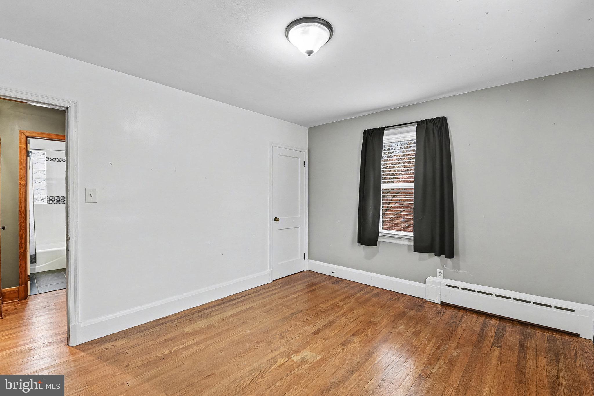 4818 Ridge Road Rosedale, MD 21237 - Photo 21 of 30 an empty room with wooden floor and windows