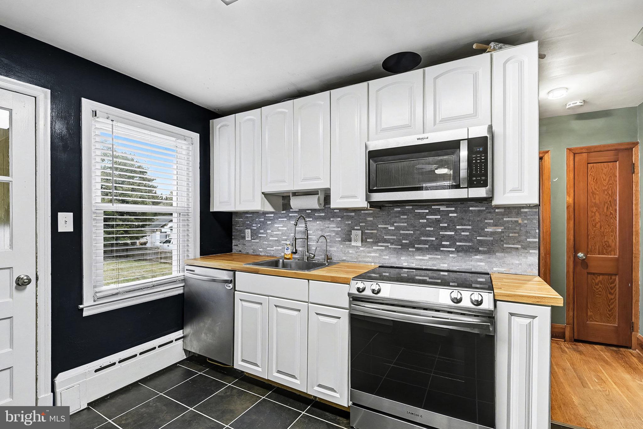4818 Ridge Road Rosedale, MD 21237 - Photo 9 of 30 a kitchen with stainless steel appliances a stove a microwave sink and cabinets