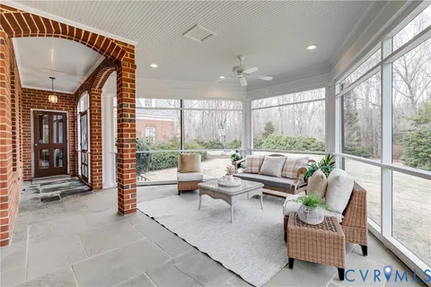 a living room with furniture a fireplace and potted plants