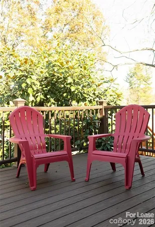 a view of a rooftop deck with chairs and wooden floor