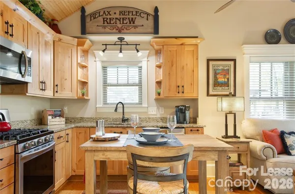 a kitchen with stainless steel appliances granite countertop a sink stove and cabinets