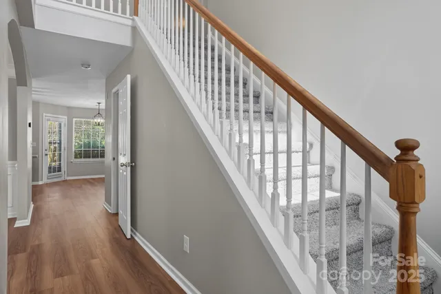 a view of staircase with wooden floor and white walls