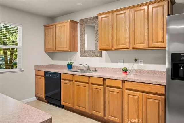 a kitchen with stainless steel appliances granite countertop a sink a refrigerator and cabinets