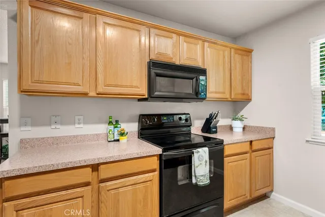 a kitchen with granite countertop cabinets stainless steel appliances and a counter space