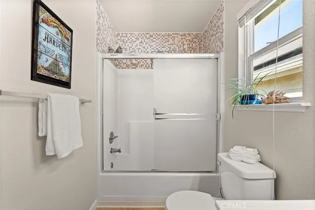 a bathroom with a toilet a sink and a window