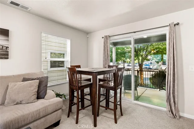 a dining room with furniture and large windows