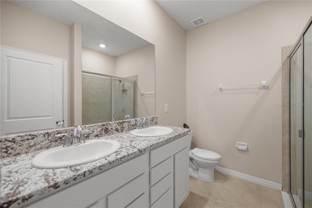 5369 Northwest 48th Lane Ocala, FL 34482 - Photo 17 of 47 a bathroom with a granite countertop sink a mirror and a toilet
