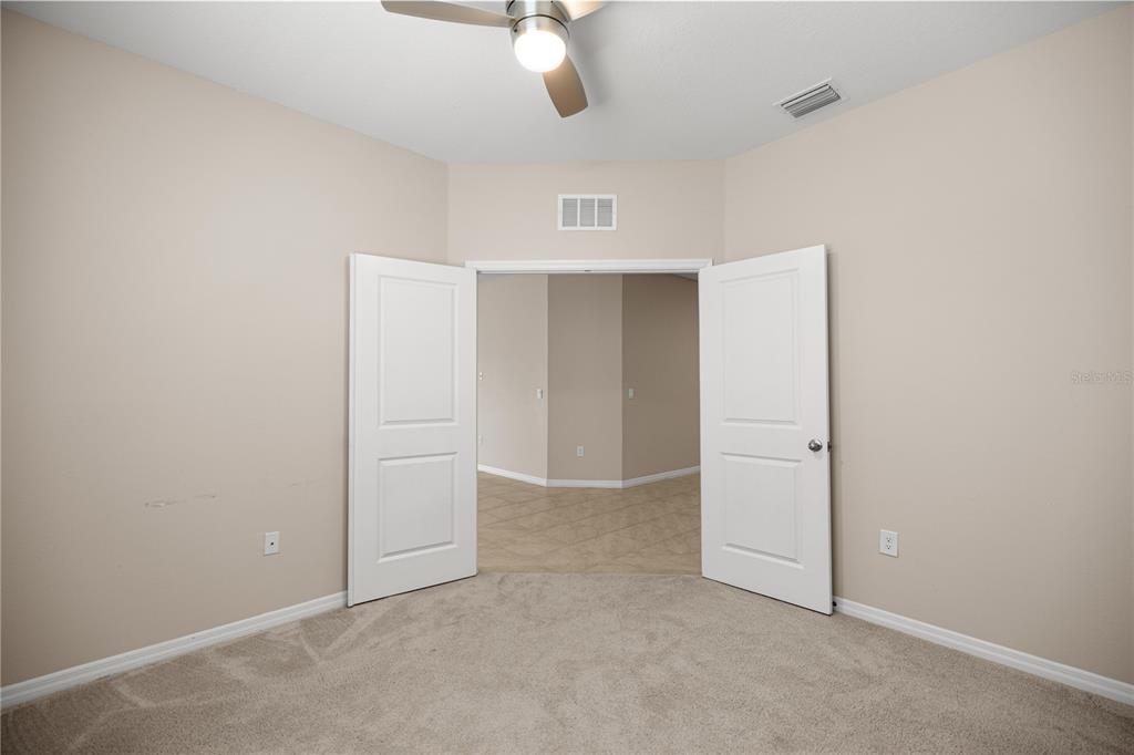 5369 Northwest 48th Lane Ocala, FL 34482 - Photo 22 of 47 an empty room with a ceiling fan and carpet