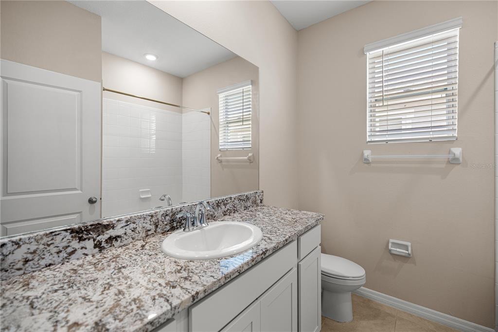 5369 Northwest 48th Lane Ocala, FL 34482 - Photo 24 of 47 a bathroom with a granite countertop sink toilet and mirror