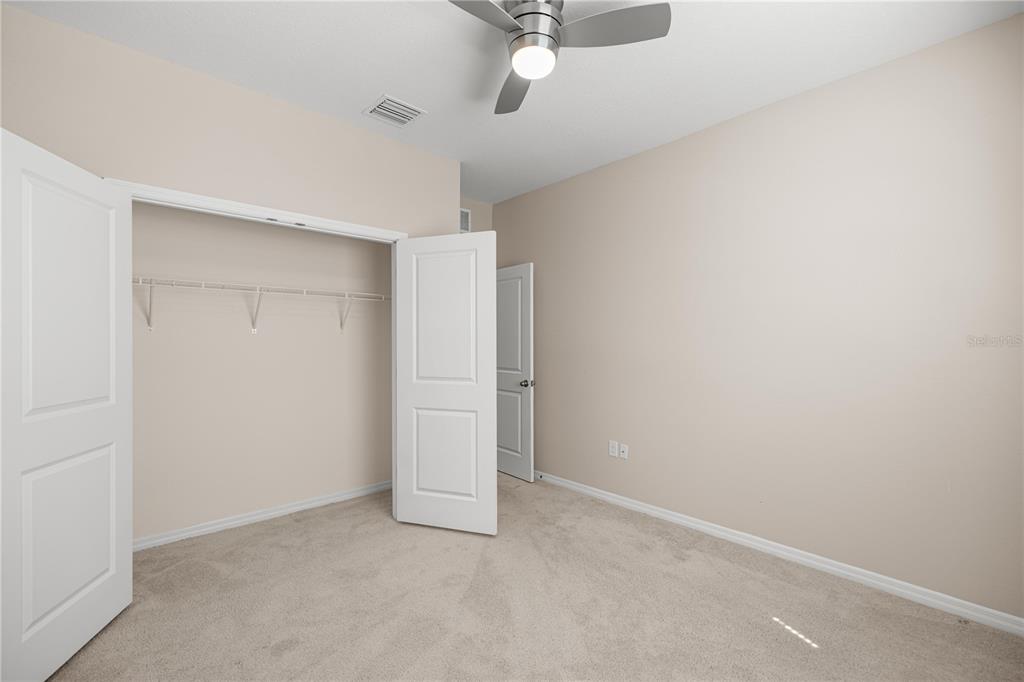 5369 Northwest 48th Lane Ocala, FL 34482 - Photo 28 of 47 an empty room with a ceiling fan and carpet
