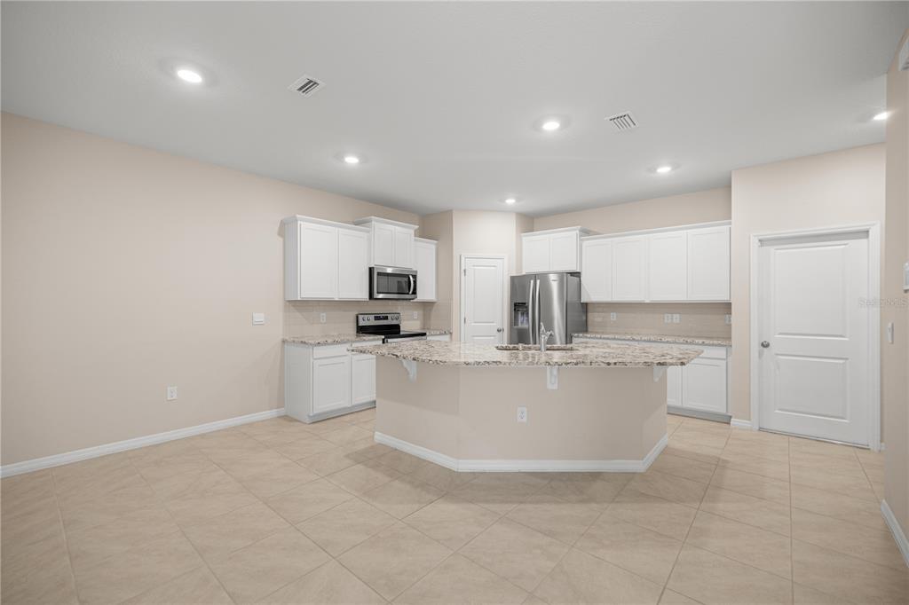 5369 Northwest 48th Lane Ocala, FL 34482 - Photo 9 of 47 a view of kitchen with stainless steel appliances a white stove top oven cabinets and white floor