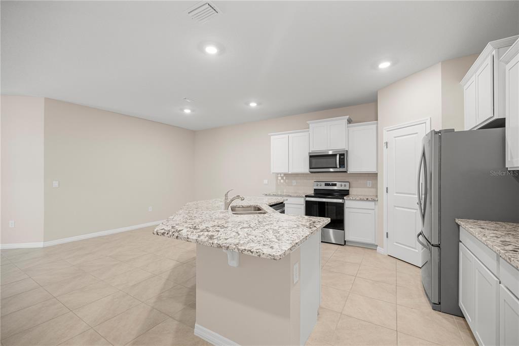 5369 Northwest 48th Lane Ocala, FL 34482 - Photo 10 of 47 a kitchen with a refrigerator a stove top oven and a sink
