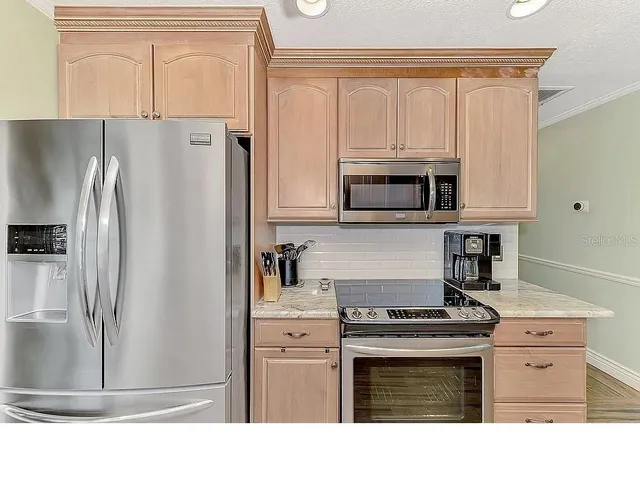 a living room with furniture a flat screen tv and kitchen view