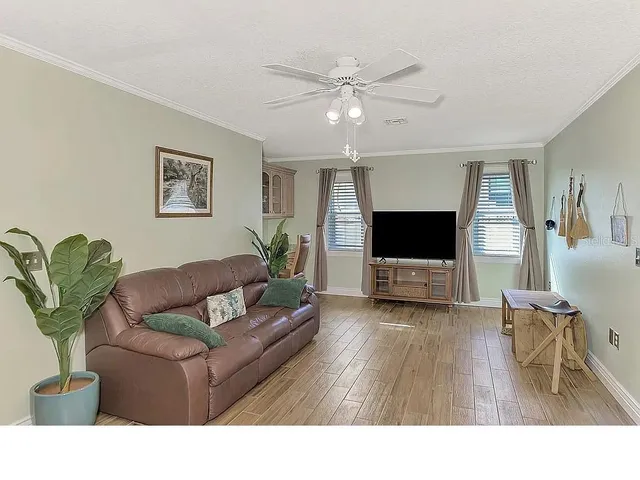 a living room with furniture a dining table and a chandelier