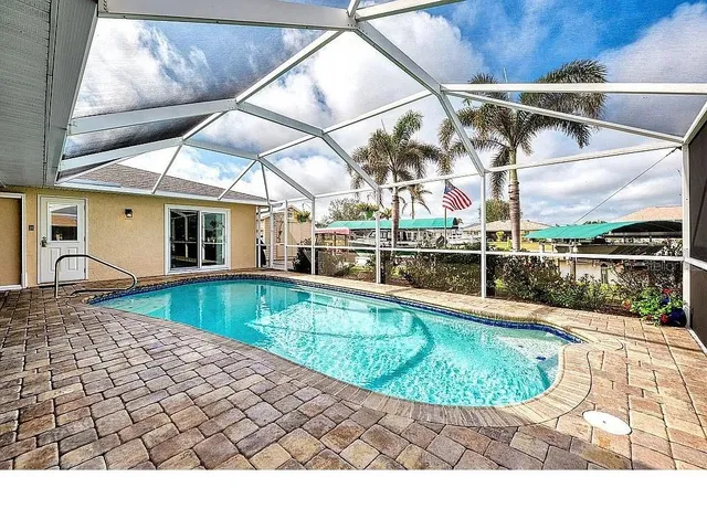 an aerial view of a house with swimming pool patio and outdoor seating