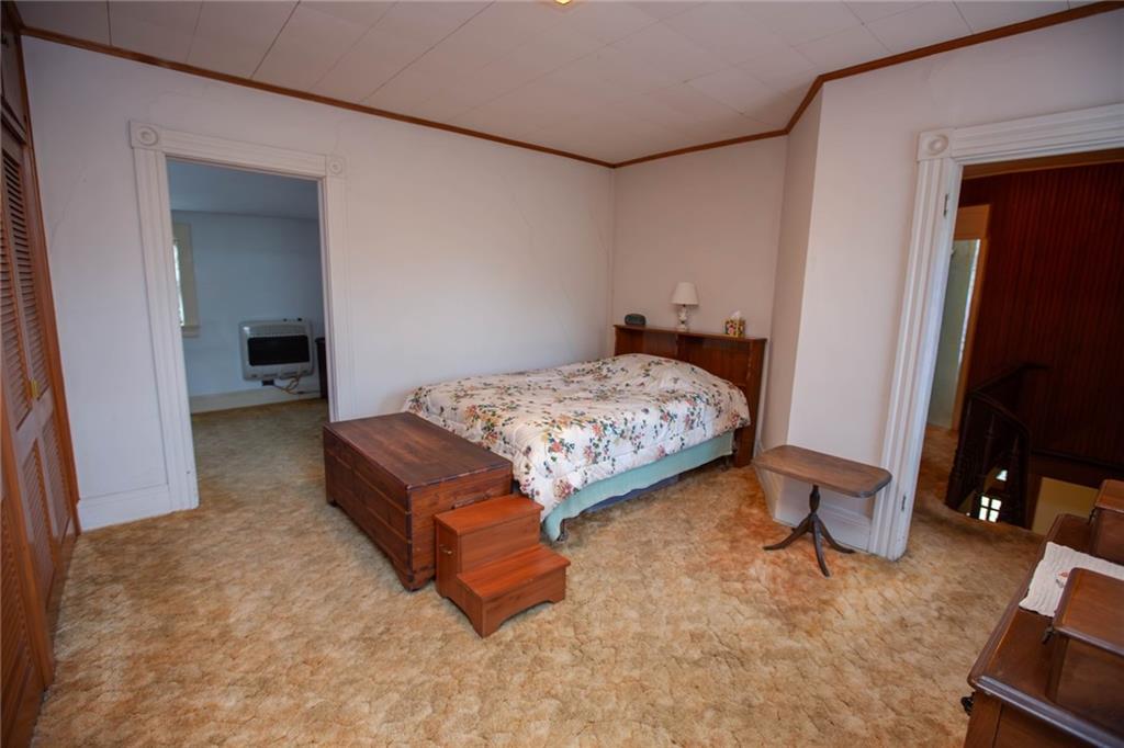 195 West W Railroad Road Sycamore, PA 15364 - Photo 43 of 50 a bedroom with a bed and a flat tv screen on wall