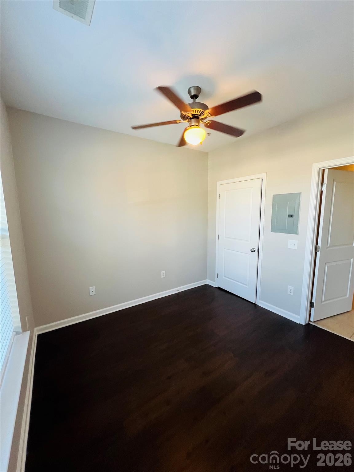 4310 Park Road, Unit 207 Charlotte, NC 28209 - Photo 5 of 9 an empty room with wooden floor a ceiling fan and a window