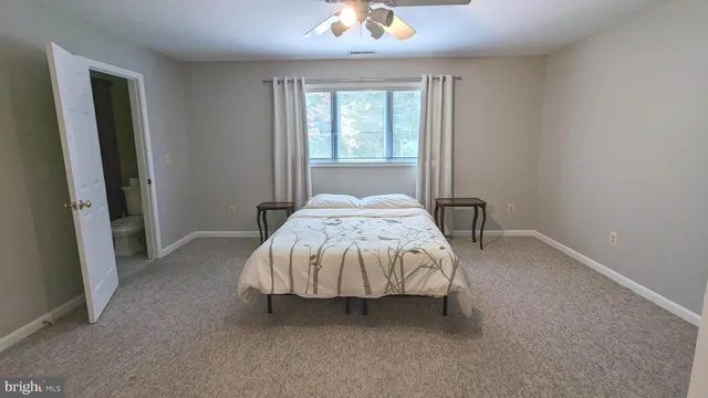 a bed sitting in a bedroom next to a window and a chandelier