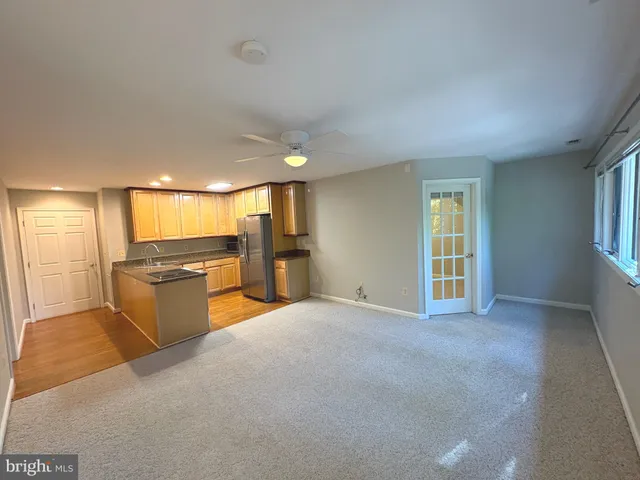 a view of a kitchen with kitchen island wooden floor and stainless steel appliances
