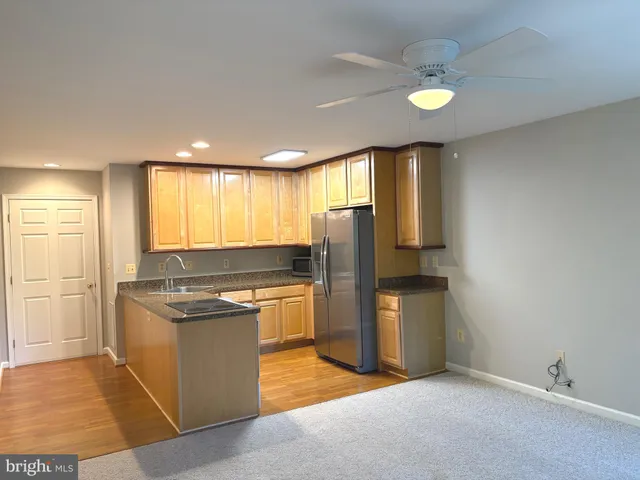 a kitchen with stainless steel appliances granite countertop a refrigerator a sink and a stove