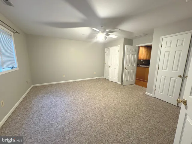 an empty room with closet and windows