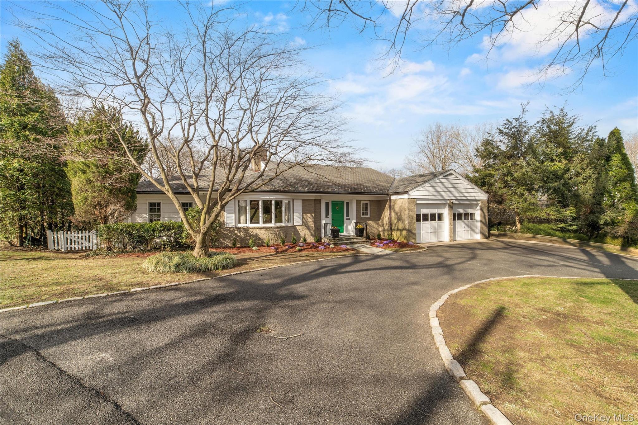 52 Oakledge Road Bronxville, NY 10708 - Photo 32 of 39 View of front facade with driveway, an attached garage, and fence