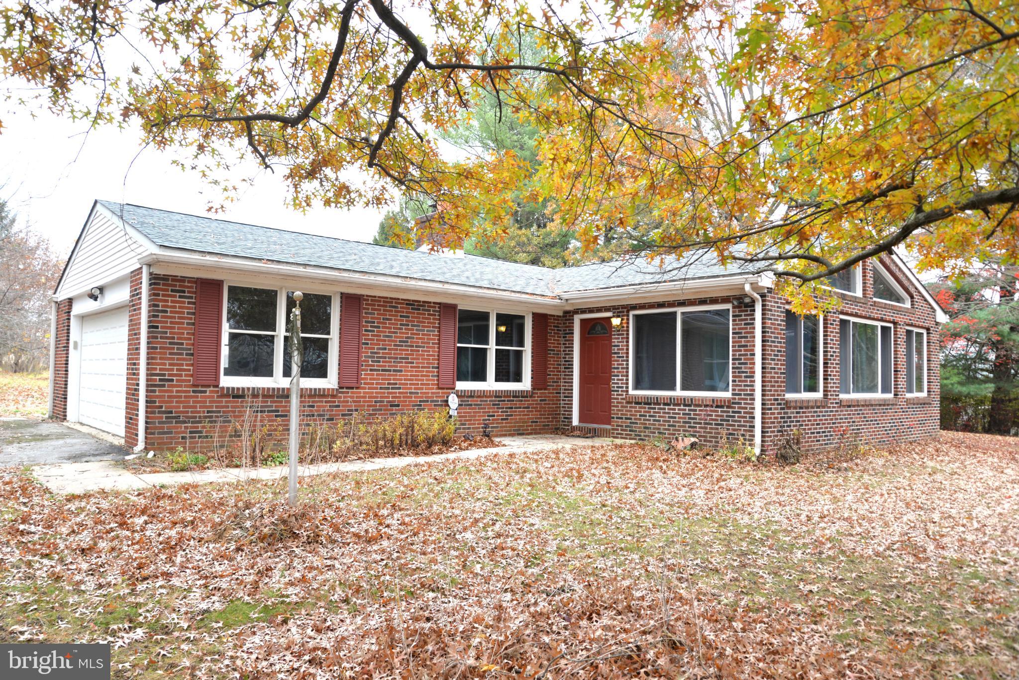 208 Faggs Manor Road Cochranville, PA 19330 - Photo 3 of 35 Charming brick home amidst autumn leaves.