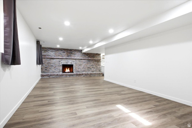 1676 East 11245 South Sandy, UT 84092 - Photo 22 of 34 Spacious room featuring wood-finish flooring, recessed lighting, and a prominent brick fireplace