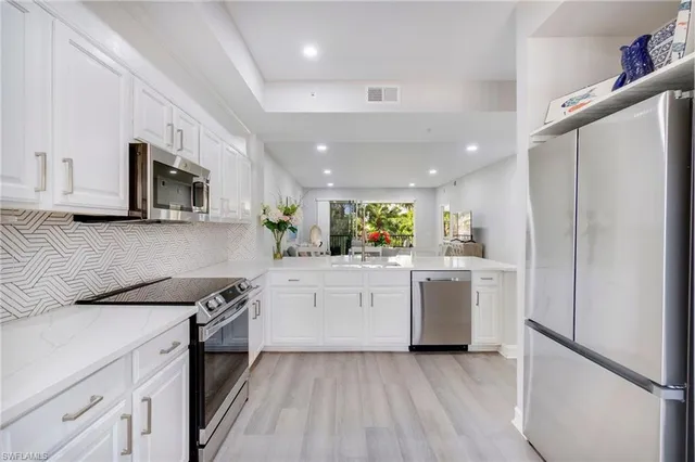 a kitchen with white cabinets and stainless steel appliances