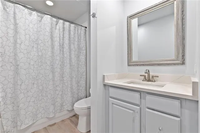 a bathroom with a toilet a sink a vanity and mirror