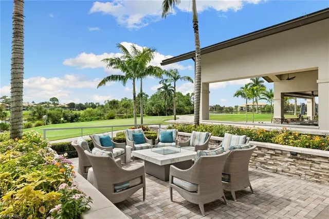 a view of a patio with couches potted plants and a big yard