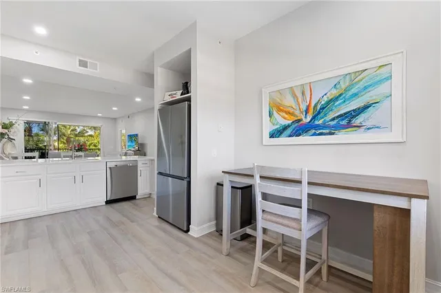 a kitchen with a refrigerator and white cabinets