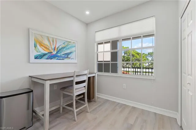 a view of a workspace with furniture and a window