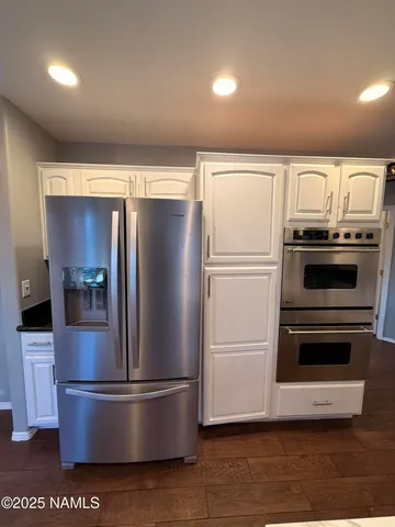 a metallic refrigerator freezer sitting in a kitchen