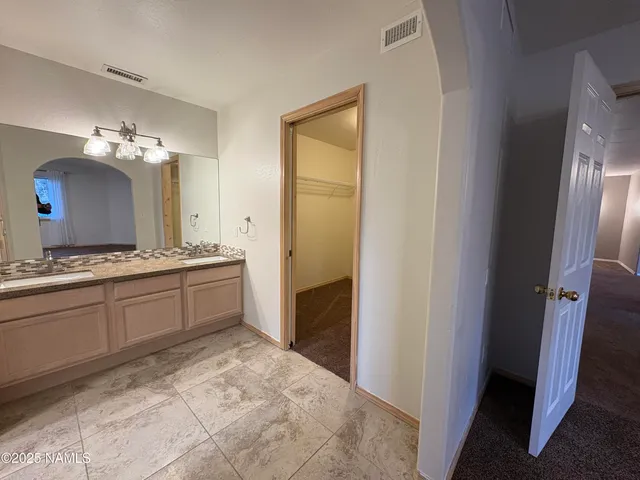 a spacious bathroom with a mirror and a sink