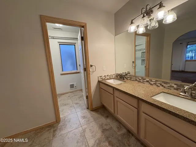 a bathroom with a granite countertop sink a mirror and a vanity