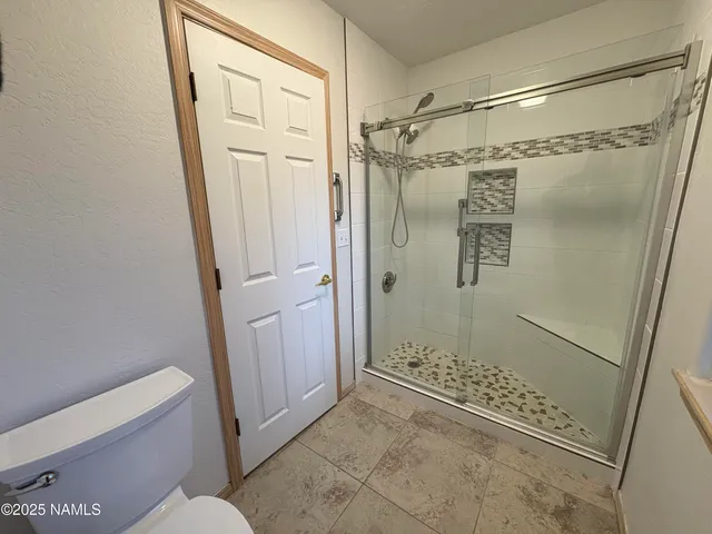 a bathroom with a glass door shower and toilet