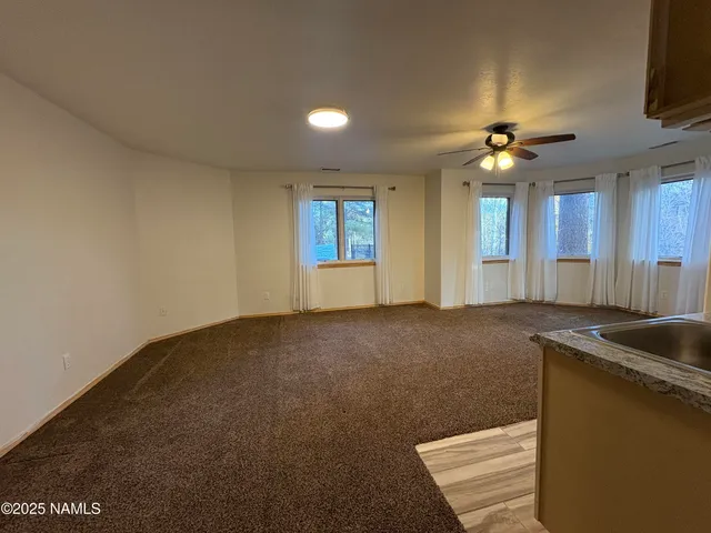 a view of an empty room with a kitchen