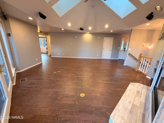 a view of an empty room with wooden floor