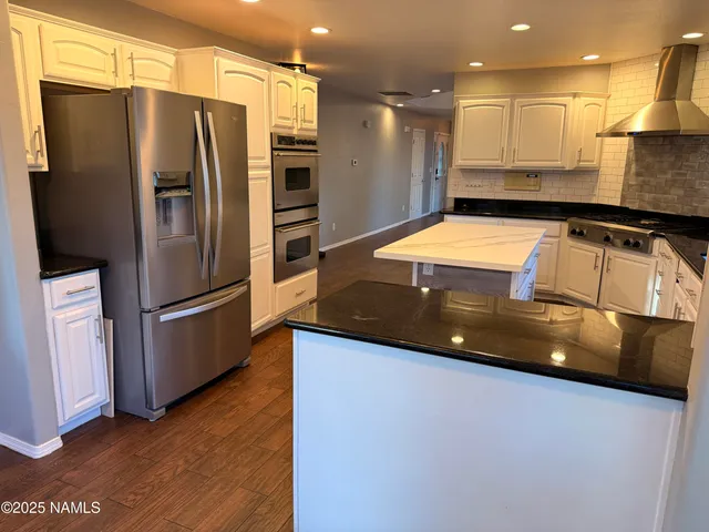 a kitchen with stainless steel appliances a refrigerator a stove a sink and a refrigerator