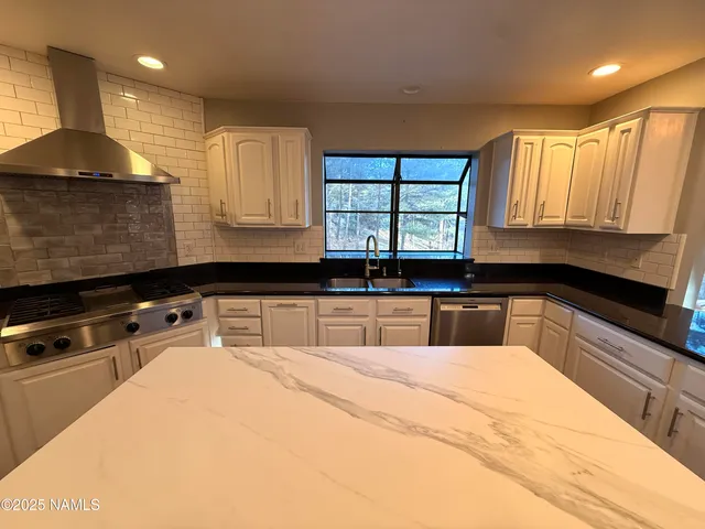 a kitchen with a sink a stove and a window